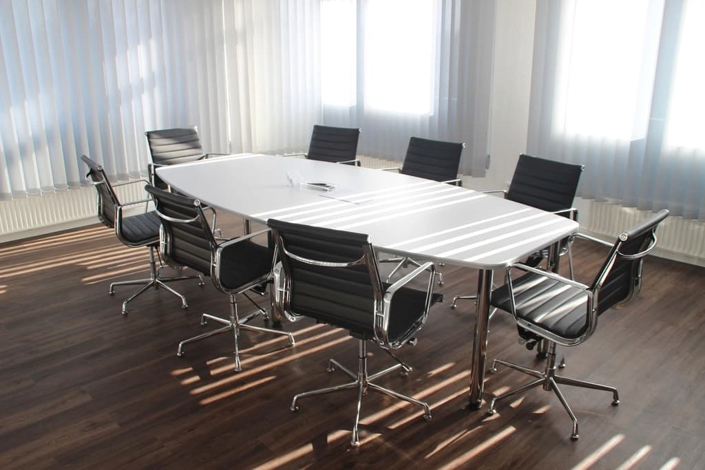 Salle de réunion lumineuse avec une grande table blanche